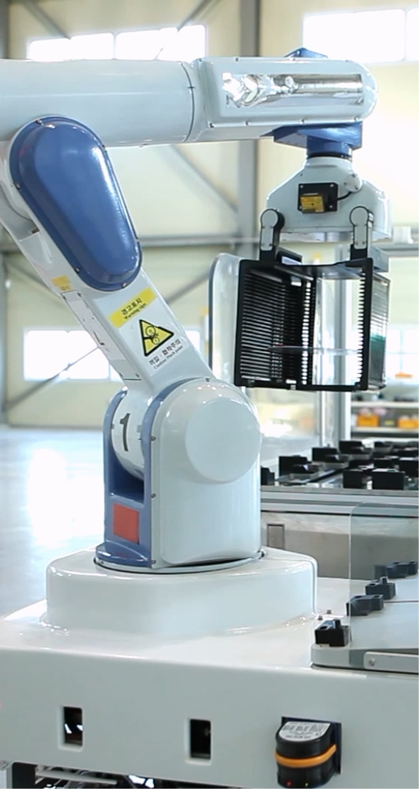 Robot arm lifting a cassette of wafers on the fab floor